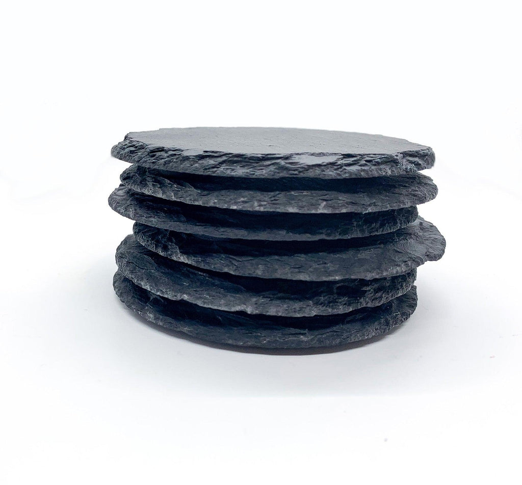 Handcrafted stack of six dark slate coasters with natural chiseled edges shown on a clean white background.