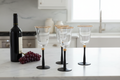4 Black Stemmed Gold Rim Wine Glasses on Marble Counter